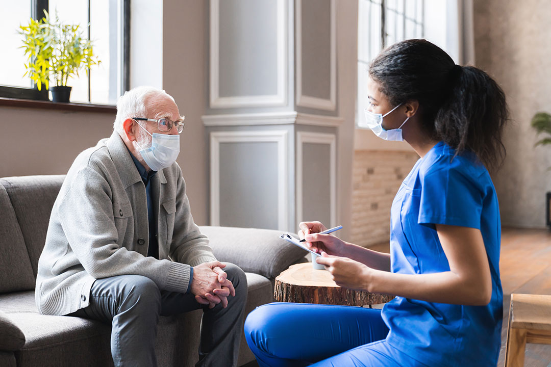 Young nurse caring for elder man at nursing home